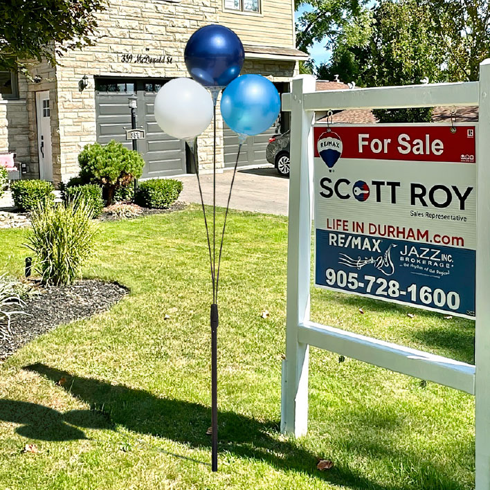 In-ground 3-balloon cluster next to an Open House sign.