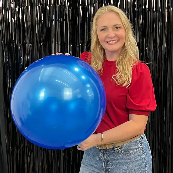 Woman holding a 17&rdquo; blue reusable vinyl balloon. 