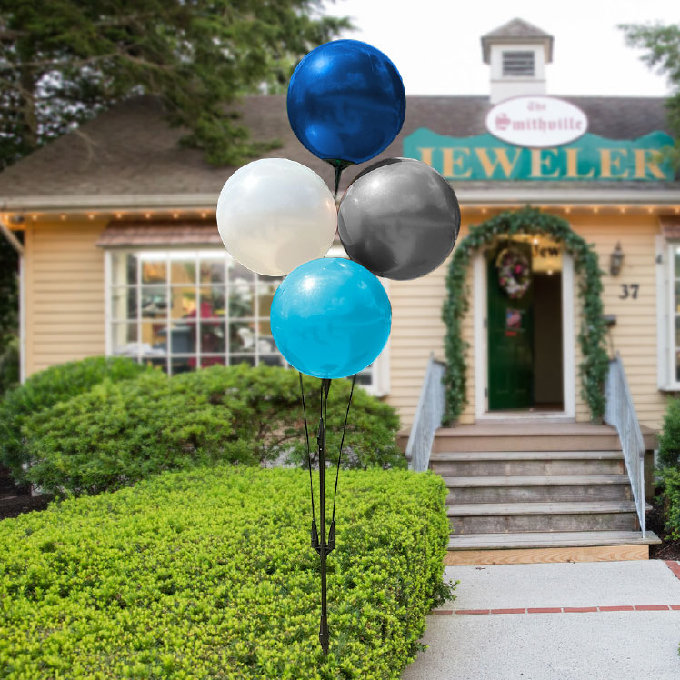 A cluster of 4 vibrant reusable balloons in front of a small business.