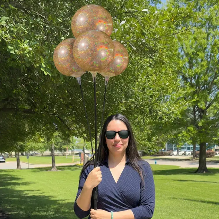 Girl standing next to a 4-balloon outdoor cluster with 8-inch vinyl balloons in new glitter collection. 